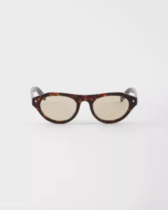 アイコニックなメタルプレートをあしらったPradaのサングラス