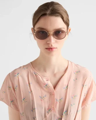 アイコニックなメタルプレートをあしらったPradaのサングラス
