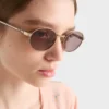アイコニックなメタルプレートをあしらったPradaのサングラス
